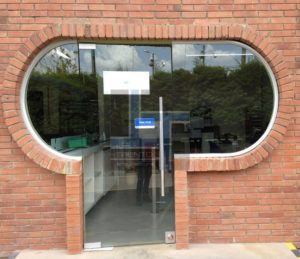 acceso arquitectónico con puertas en vidrio y estructura en aluminio