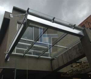 marquesina en vidrio y aluminio para entrada principal con diseño arquitectónico moderno